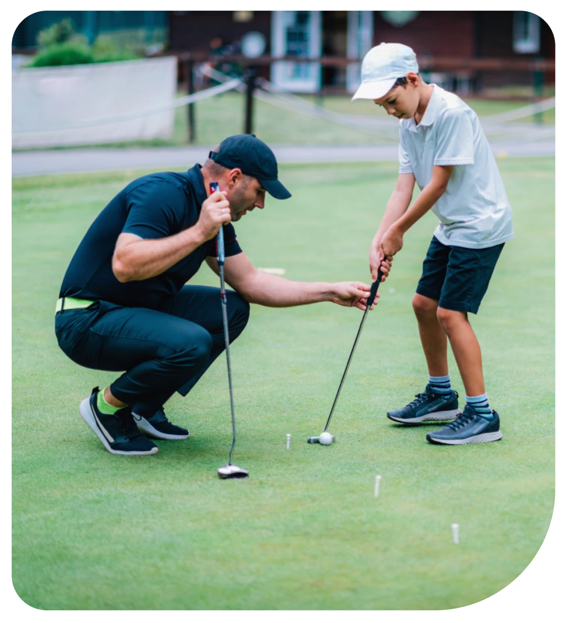 Father helping son putt on green